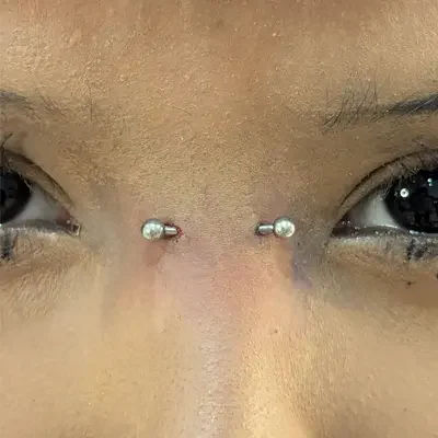 Close up of a woman's face showing a bridge piercing.